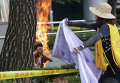 Женщина пытается потушить мужчину, устроившего самосожжение на митинге перед посольством Японии в Сеуле