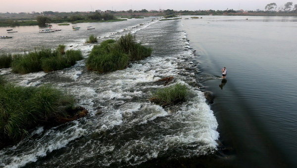 Мужчина спасается от жары в реке Нил на окраине Каира, Египет