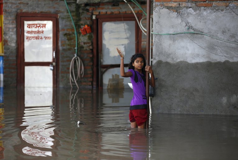 Девочка стоит возле своего дома, залитого вследствие проливных дождей в Катманду, Непал