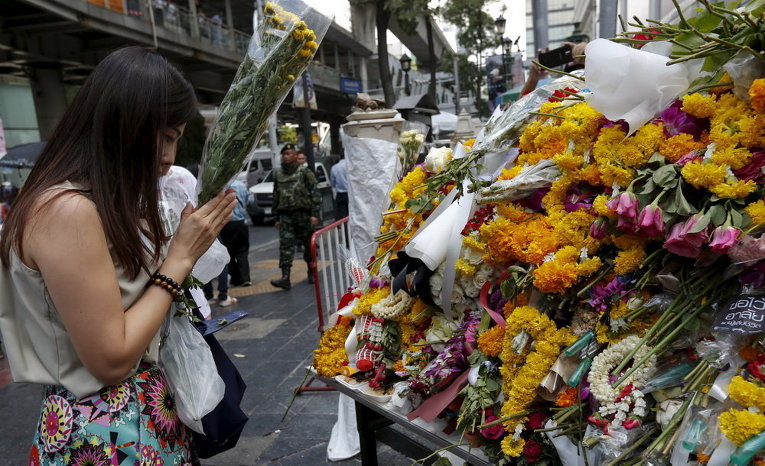 Женщина пришла с цветами к месту смертельного взрыва в центре Бангкока, Таиланд