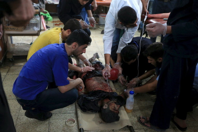Медики в полевом госпитале пытаются спасти раненого после авиаудара в Дамаске, Сирия