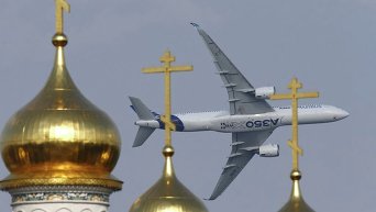 Самолет Airbus A350 XWB летит над куполами православной церкви