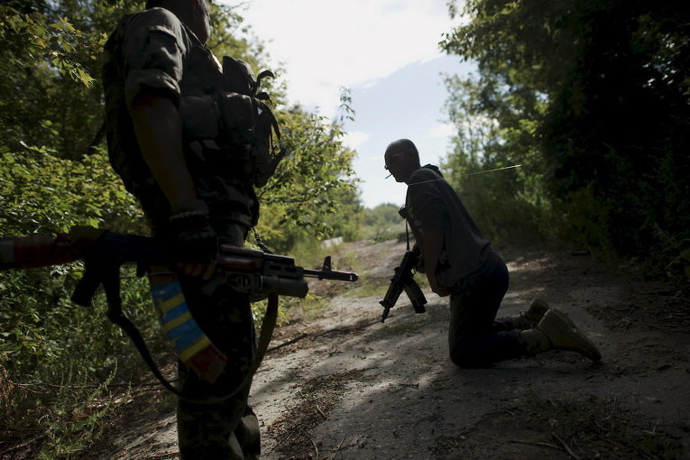 Украинские военнослужащие проходят под ловушкой во время патрулирования территории возле села Попасная Луганской области