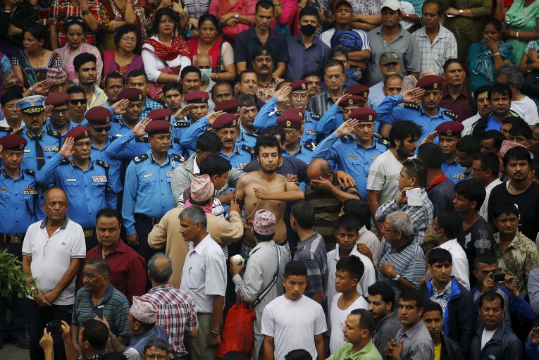 Сын убитого полицейского в западном районе Непала, Кайлали, исполняет специальный ритуал. Полицейский был убит протестующими против правительственных реформ.