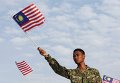 Военный держит флаг Малайзии