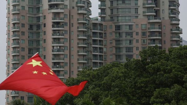 Национальный флаг Китая на фоне жилых домов
