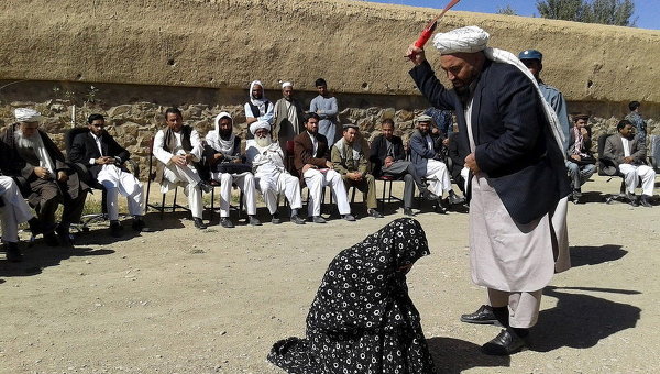 Афганский судья бьет женщину кнутом перед толпой в провинции Гор, в Афганистане, за супружескую измену