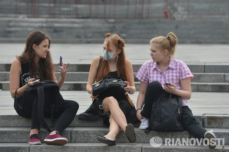 Киевляне носят маски после того, как столицу Украины накрыло дымом