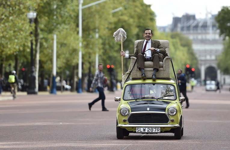 Британский комик Роуэн Аткинсон в роли мистера Бина едет на машине в центре Лондона