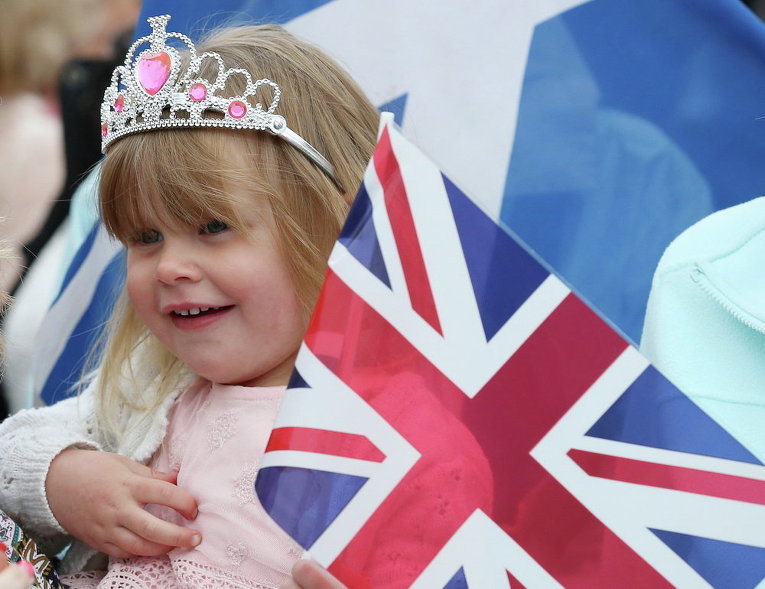 Девочка в толпе, которая ждет прибытия британской королевы Елизаветы II на церемонию открытия железной дороги в Шотландии