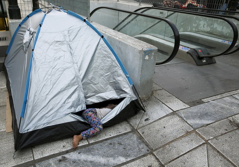 Девочка-беженка в палатке на площади Виктория в центре Афин, Греция