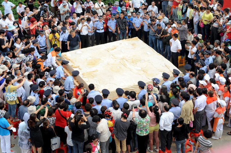Люди фотографируют тофу, соевый творог,  весом восемь тонн, в ходе мероприятия в Хуайнань, провинции Аньхой, Китай. 50 поваров готовили тофу в течение семи часов.