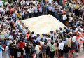 Люди фотографируют тофу, соевый творог,  весом восемь тонн, в ходе мероприятия в Хуайнань, провинции Аньхой, Китай. 50 поваров готовили тофу в течение семи часов.