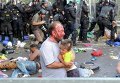 Травмированный мигрант несет ребенка во время столкновений с полицией Венгрии