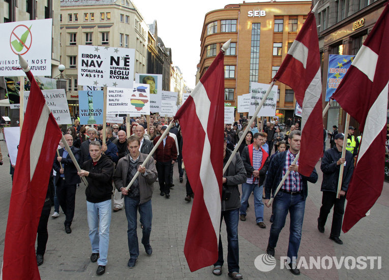 Шествие против приема беженцев в Риге под национальными флагами Латвии