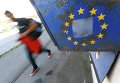 Мигранты проходят мимо флага ЕС