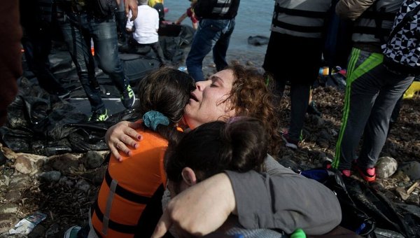 Сирийские беженцы радуются тому, что добрались из Турции на греческий остров Лесбос.