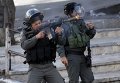 Израильский пограничный полицейский стреляет резиновыми пулями по палестинским демонстрантов во время столкновений в мечети Аль-Акса в Иерусалиме.