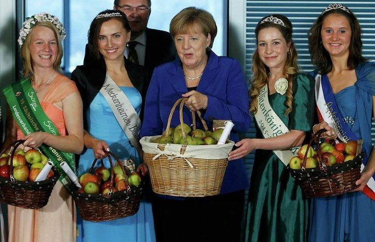 Канцлер ФРГ Ангела Меркель позирует с яблочными и цветочными королевами, которые представили яблоки из разных садов Германии