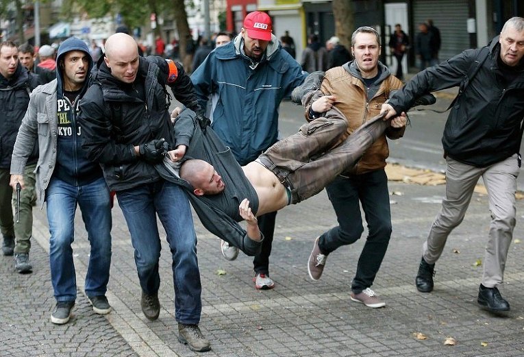 Полицейские, одетые в гражданское, уносят участника антиправительственных протестов в Брюсселе, Бельгия
