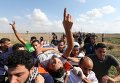 Палестинцы несут раненого демонстранта, который был ранен израильскими войсками, во время столкновений возле израильской границы забора на северо-востоке сектора Газа.