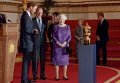 Принц Гарри, герцог Эдинбургский и королева Елизавета в Букингемском дворце смотрят на Кубок Уэбба Эллиса, вручаемый команде, победившей на чемпионате мира по регби