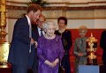 Принц Гарри и королева Елизаветта в Букингемском дворце смотрят на Кубок Уэбба Эллиса во время приема