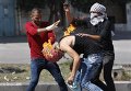 Палестинский протестующий неудачно бросил коктейль Молотова в израильских полицейский и подпалил себя, на фото - товарищи оказывают ему помощь