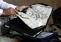 Полиция в Лиме показывает фальшивые доллары, спрятанные в сумке, на конференции.