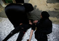 Бахрейнские женщины помогают участнику акции протеста, в которого попал слезоточивый газ