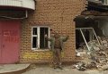 Георгий Тука на фоне разрушенного офиса КПУ в Лисичанске