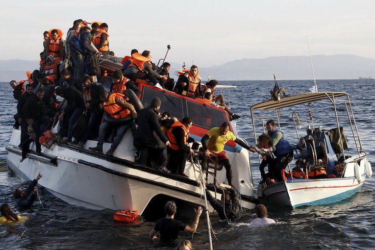 Греческая рыбацкая лодка эвакуирует людей из наполовину затонувшего катамарана, на борту которого было около 150 беженцев, большинство из них - сирийцы