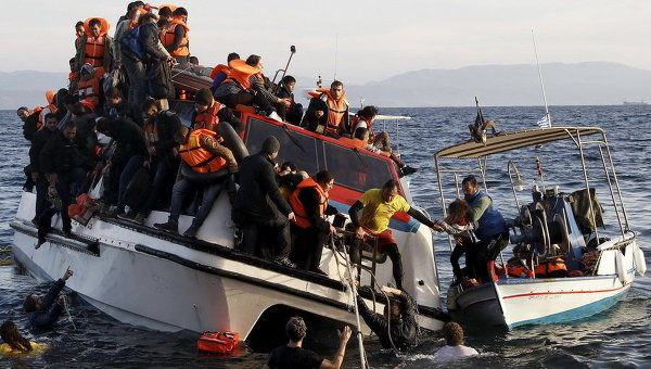 Греческая рыбацкая лодка эвакуирует людей из наполовину затонувшего катамарана, на борту которого было около 150 беженцев, большинство из них - сирийцы