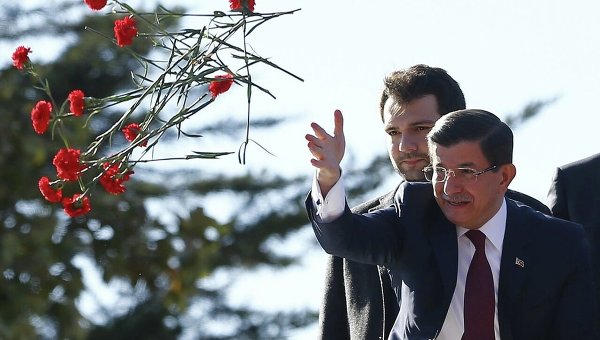 Премьер-министр Давутоглу бросает сторонникам правящей партии гвоздики после победы на парламентских выборах в Турции.