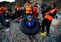Беженцы в турецкой провинции Измир собираются на пляже перед отплытием на греческий остров Хиос