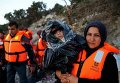 Беженцы в турецкой провинции Измир собираются на пляже перед отплытием на греческий остров Хиос