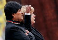Боливийский президент Моралес слушает боливийский гимн рядом с канцлером Германии Ангелой Меркель в Берлине