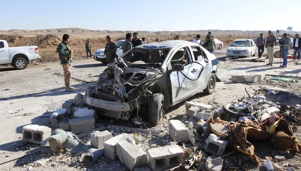 Члены курдских повстанцев у разрушенного автомобиля в городе Дибис, на северо-западе от Киркука