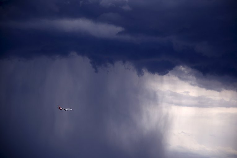 Boeing 737-800 летит через сильный дождь над Сиднеем, Австралия