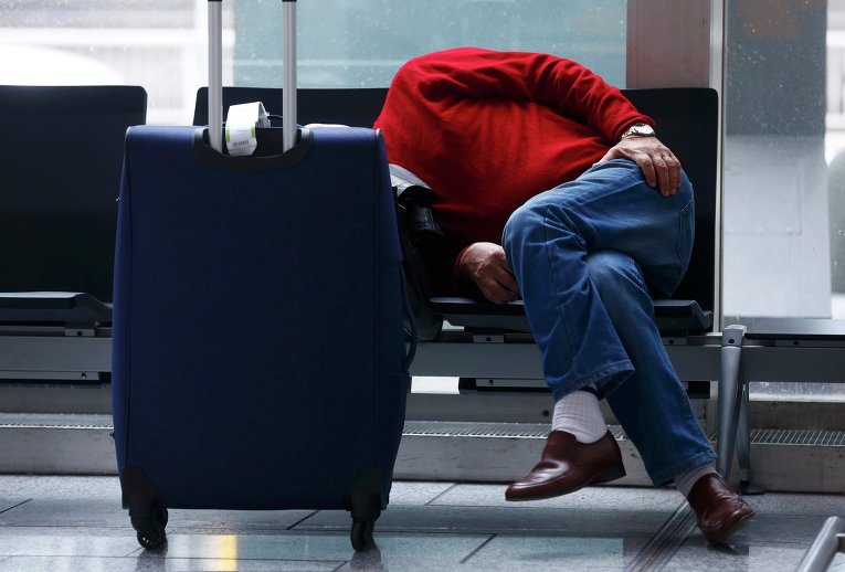 Пассажир спит в аэропорту Франкфурта, Германия. 6 ноября авиакомпания Lufthansa объявила забастовку, требуя пересмотреть условия выхода на пенсию сотрудников.
