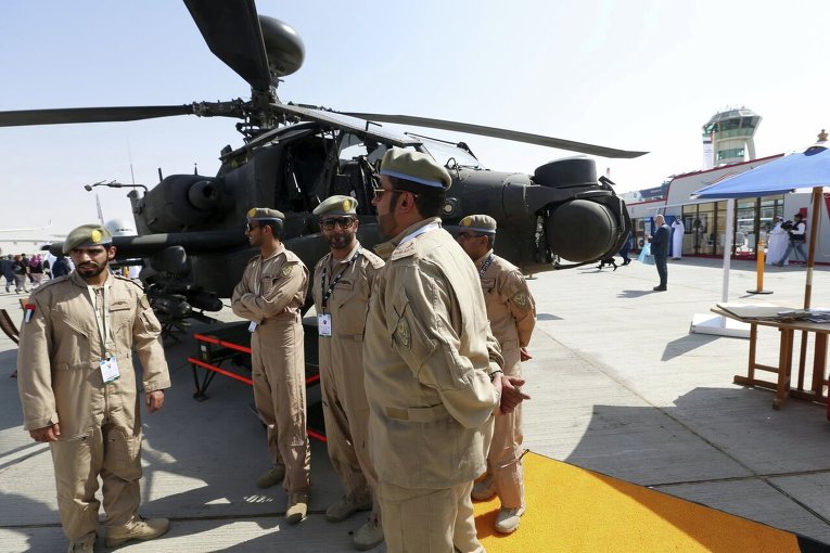 Солдаты ВВС ОАЭ рядом с вертолетом Apache на международной авиационно-космической выставке Dubai Airshow-2015